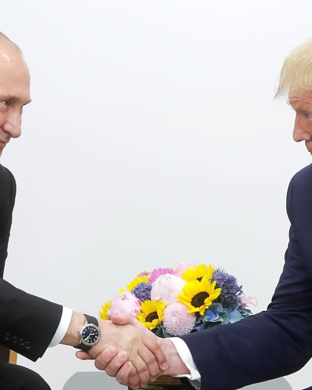 Vladimir Putin and Donald Trump shake hands
