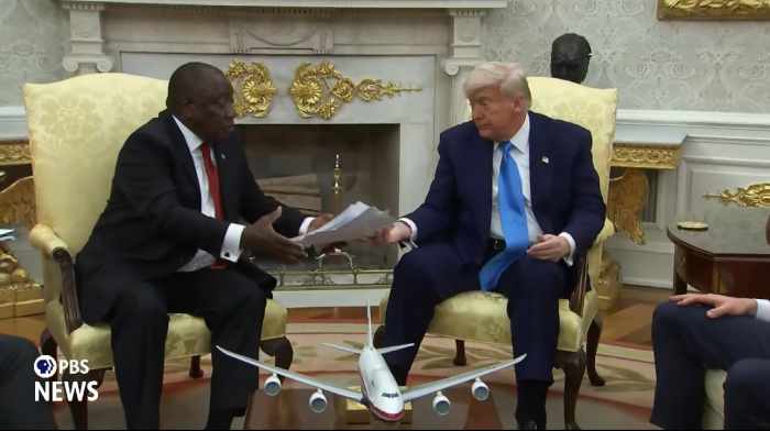 Trump handing South African President Cyril Ramaphosa a stack of articles